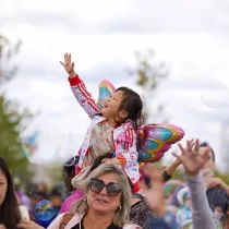 Child playing with bubbles at event.